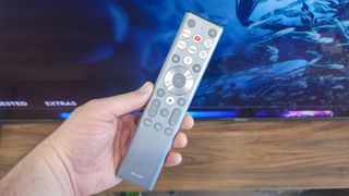 Holding a remote for the Hisense U9N Mini-LED TV