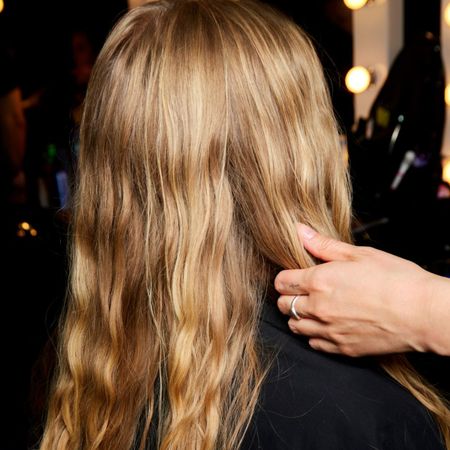 model backstage with blonde wavy hair