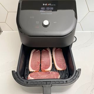 Instant Vortex Plus 6-in-1 Air Fryer with uncooked bacon in drawer