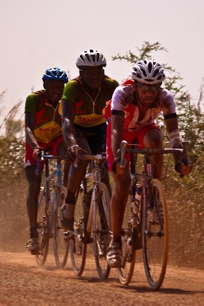 Two Benin riders follow a Cantal rider (France) on the dirt piste.