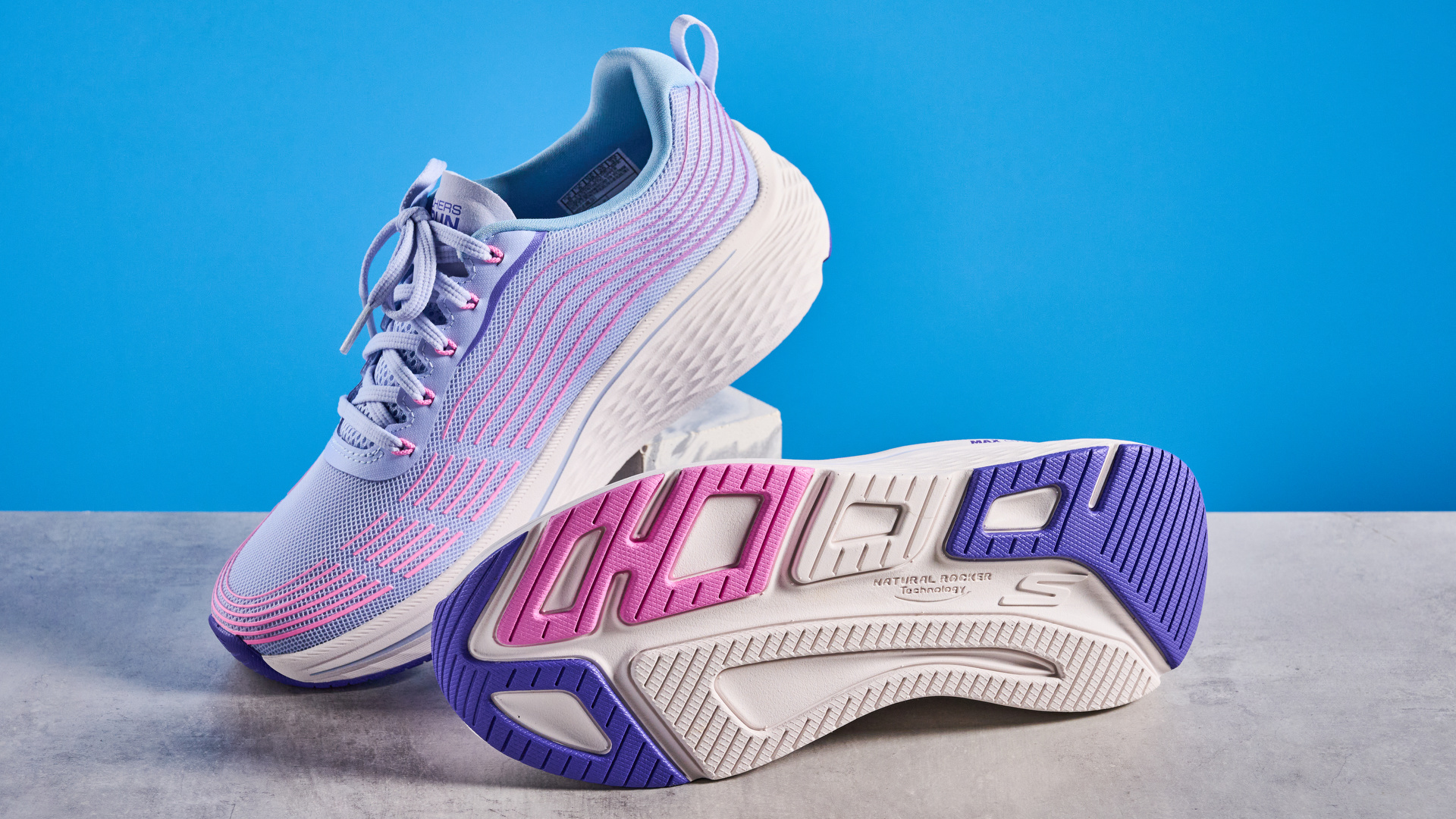 Skechers Max Cushioning Elite 2.0 running shoes photographed in front of a blue background.