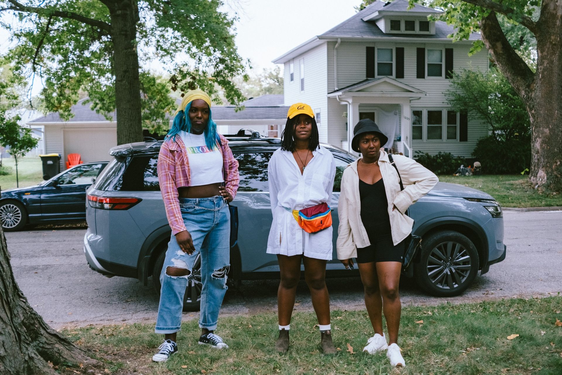 Dezi Bing, Denée Benton, and Sasha Compère as lauren z and tasha looking confused as they stand on a front lawn of a suburban street in the movie dreams in nightmares