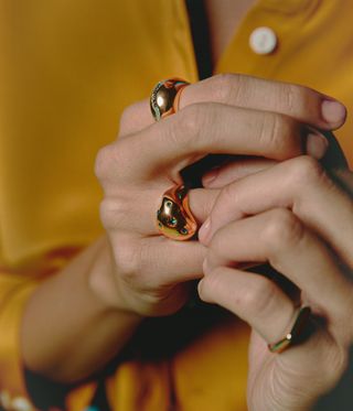 Woman wearing gold rings by colourful jewellery brand Boulo