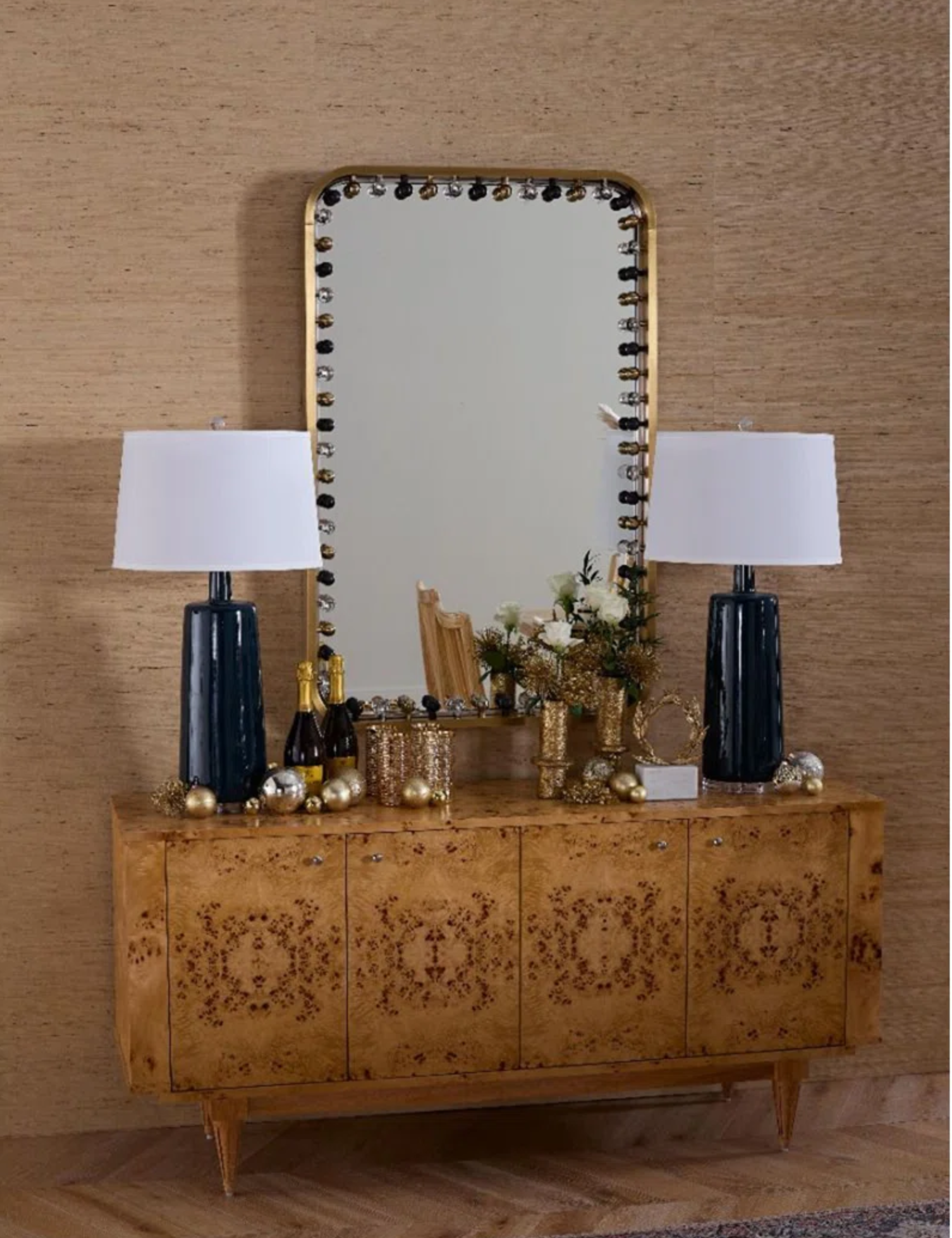 Villa & House embellished border mirror hanging over a burlwood sideboard displaying two oversized table lamps