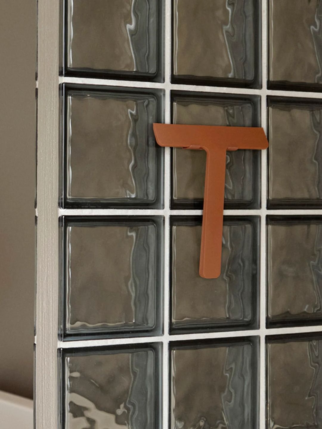 A terracotta-colored shower squeegee from Zone Denmark