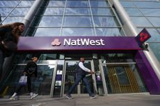 NatWest customers walk in front of a high street branch (Photographer: Hollie Adams/Bloomberg via Getty Images)