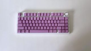 A white keyboard on a white desk with purple Cerakeys keycaps installed