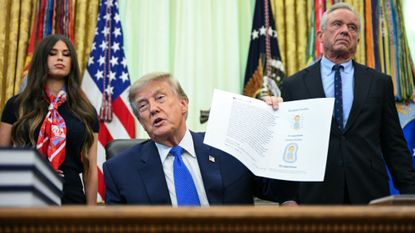 US-POLITICS-TRUMPUS Secretary of Health and Human Services Robert F. Kennedy Jr. (R) looks on as President Donald Trump speaks before signing an executive order calling for more research and flexibility on vaccines, in the Oval Office of the White House in Washington, DC, on August 10, 2026. Trump signed an executive order Monday pushing for a rethink of school vaccine mandates and repeating calls for the measles-mumps-rubella vaccine to be separated into three individual shots. Curbing vaccines has been a key priority for Health Secretary Robert F. Kennedy Jr, who founded an anti-vaccine nonprofit and has long promoted a disproven link between immunization and autism. (Photo by Jim WATSON / AFP via Getty Images)