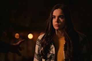 Sarah Desjardins as Callie Sadecki wearing a plaid jacket and yellow shirt in YELLOWJACKETS