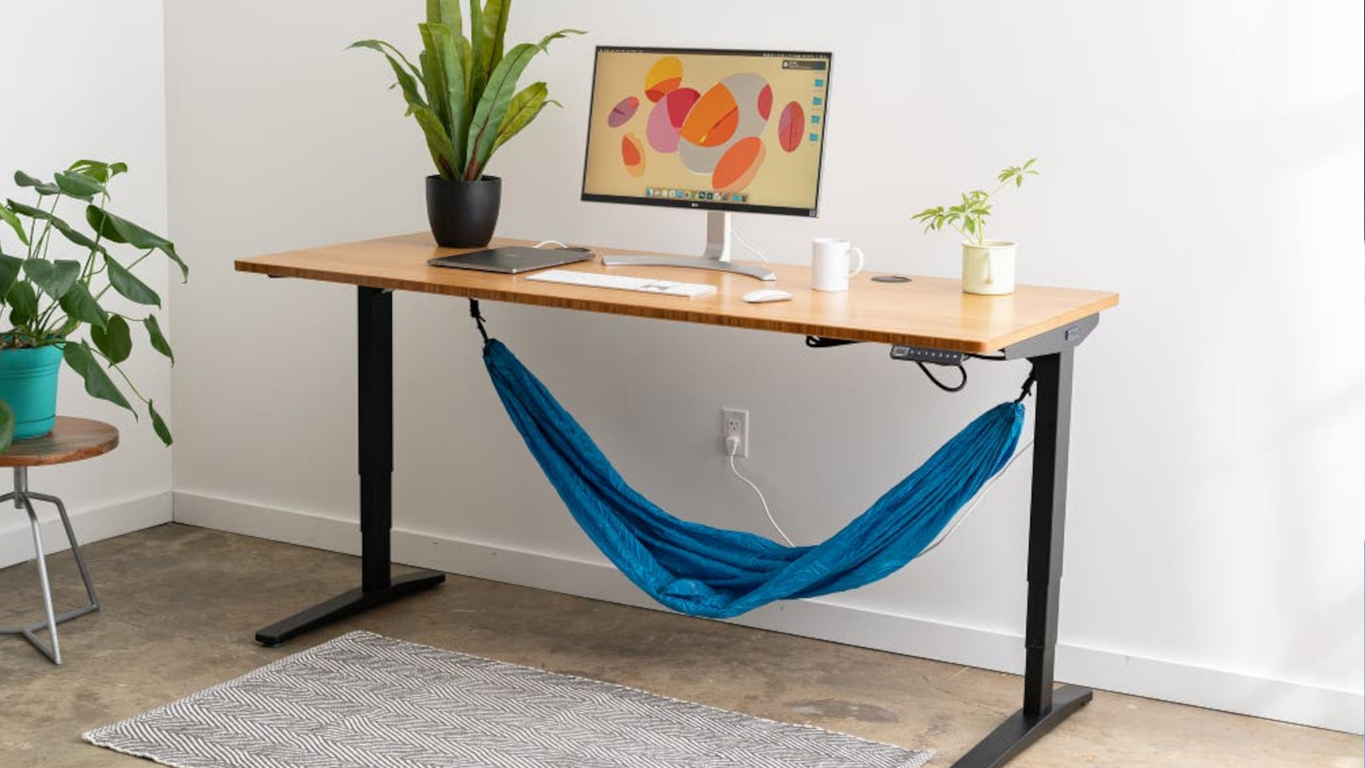 An Uplift V2 standing desk with a hammock set up underneath it