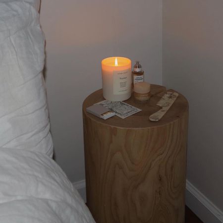 Candle burning on a bedside table