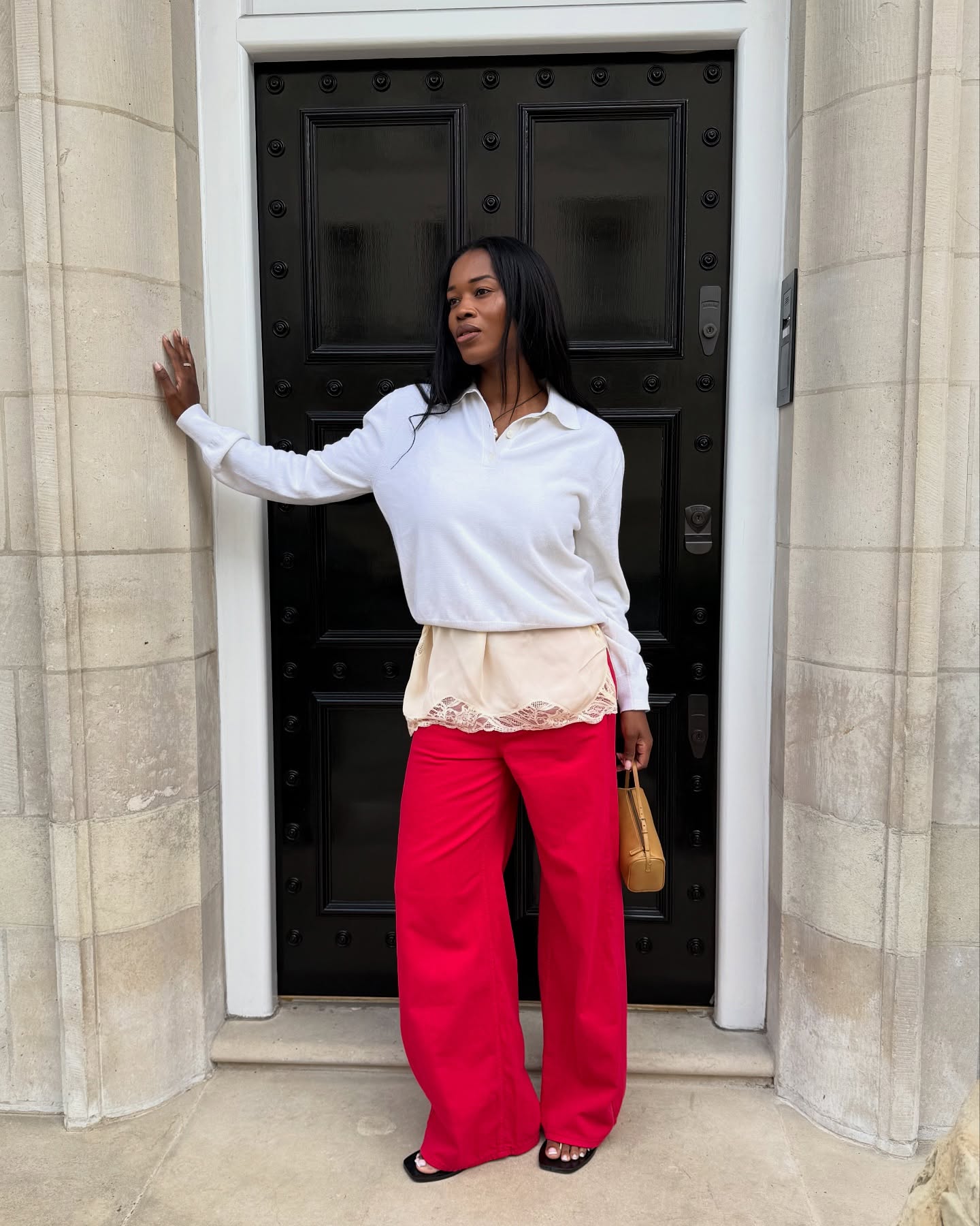 @nlmarilyn wears a pair of square-toe sandals with red trousers and grey knit