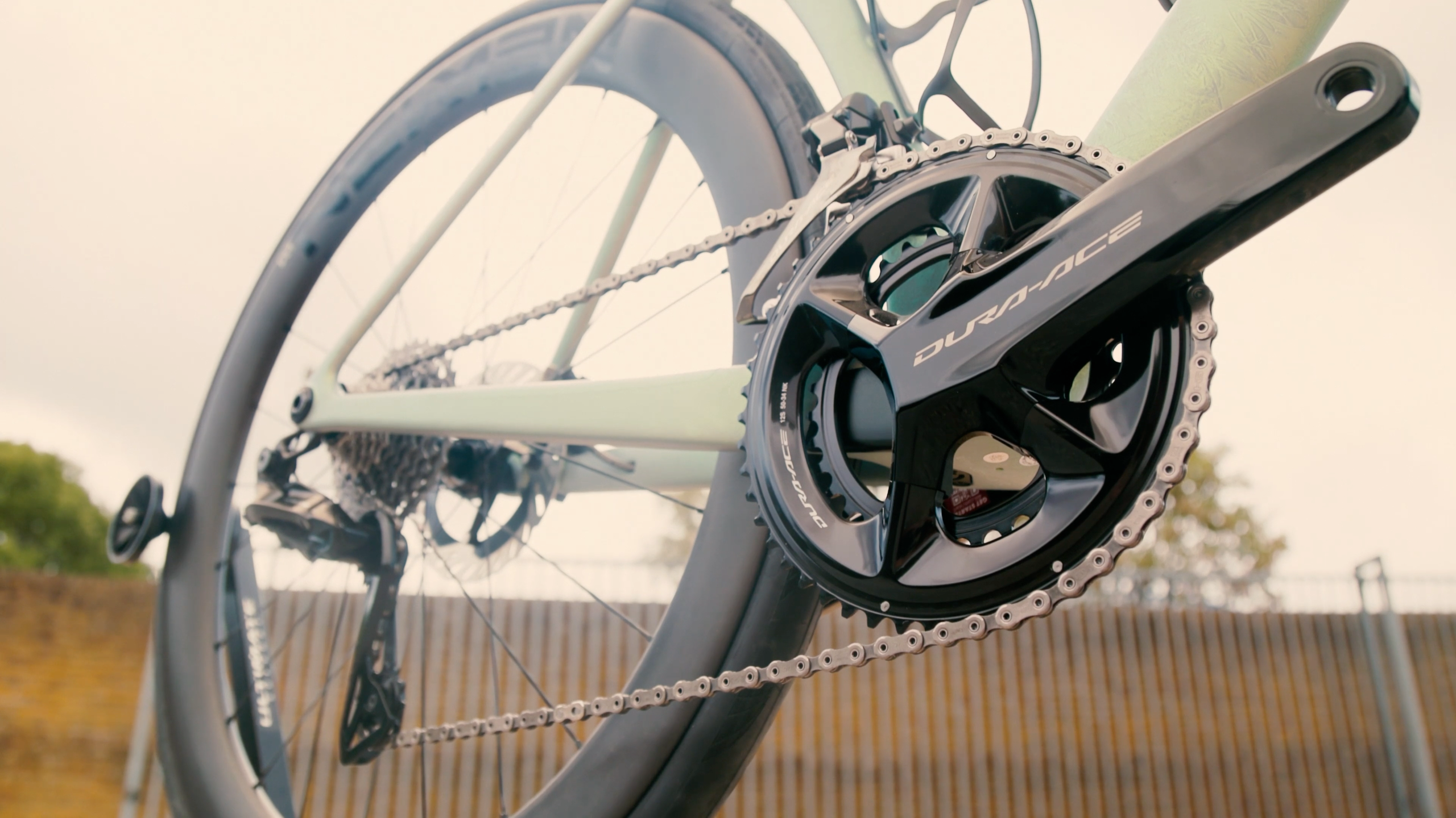 A silver bike with a black Shimano Dura-Ace crankset as the focus point of the image