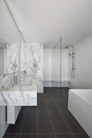 Bathroom featuring white walls and ceramic sink surface. White bath and shower