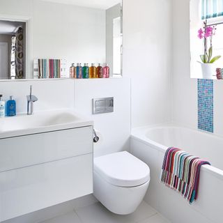 attach toilet with bathroom with white flooring and white wall