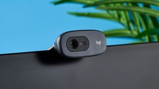 a small, black, oblong-shaped webcam with a universal attachment clip and a logi logo