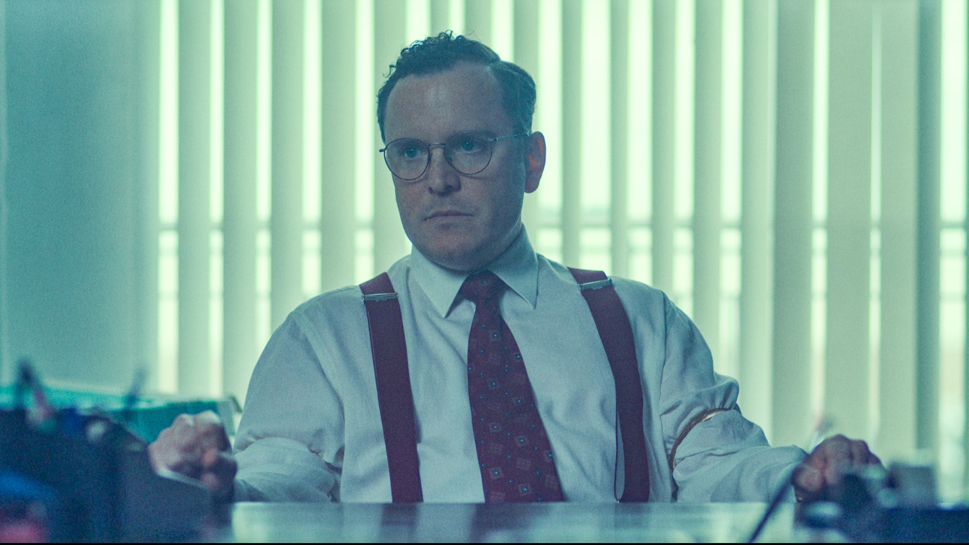 Douglas sits at his desk in The Gold season 2