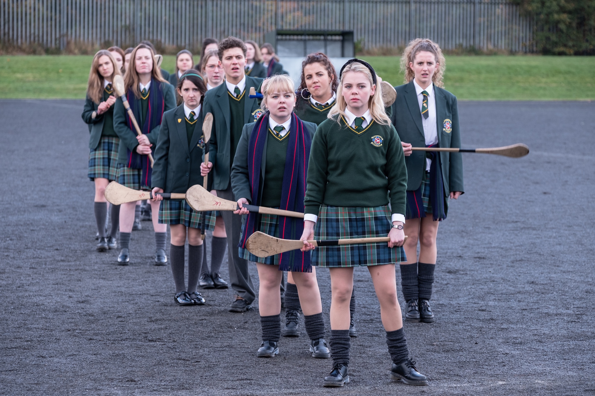 the cast of Derry Girls, lined up with paddles