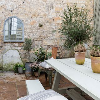 White outdoor seating area with decorative plants
