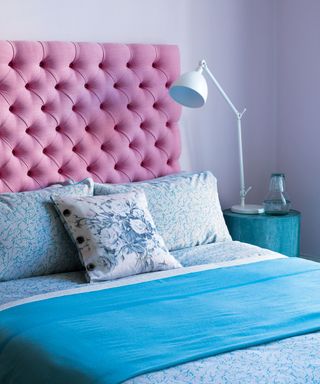 Bedroom ideas for teenagers in a pastel blue bedroom with pink headboard and white anglepoise lamp.
