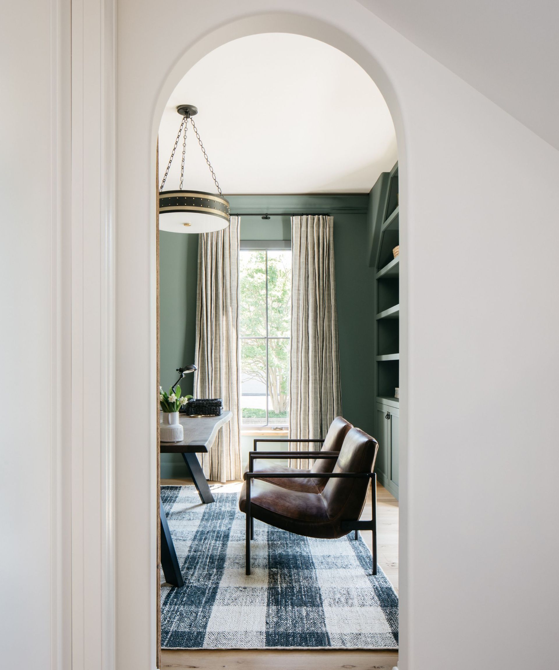 white arched doorway leading into home office painted green