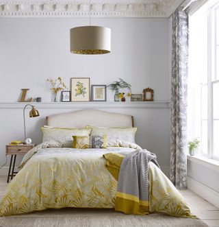 Bedroom with yellow bedding from Clarissa Hulse and grey throw