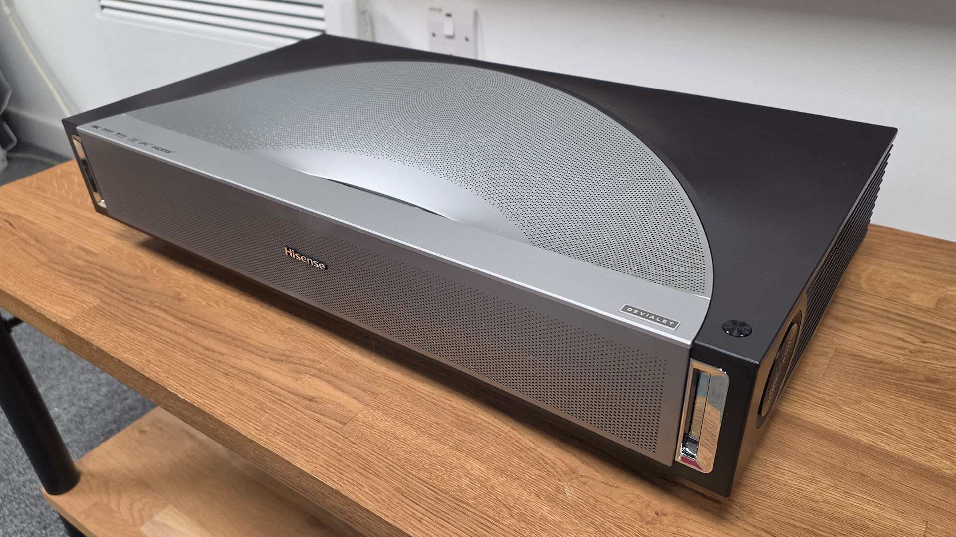 Hisense PX4 Pro UST projector on wooden AV rack