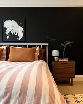 Bedroom with black wall and pink bed