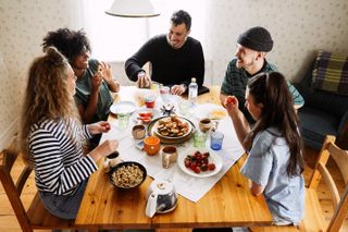 Flat mates sharing dinner with their support bubble in national lockdown