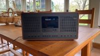 A Revo SuperConnect Stereo radio positioned on a wooden table.