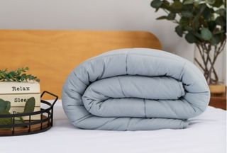 soft blue blanket folded up on a bed