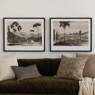 A couch with two pieces of art hung above