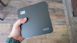 A hand holding the MSI Cubi NUC 13MQ.