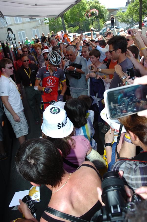 The crush of fans surround the Radioshack bus as Lance Armstrong heads out.