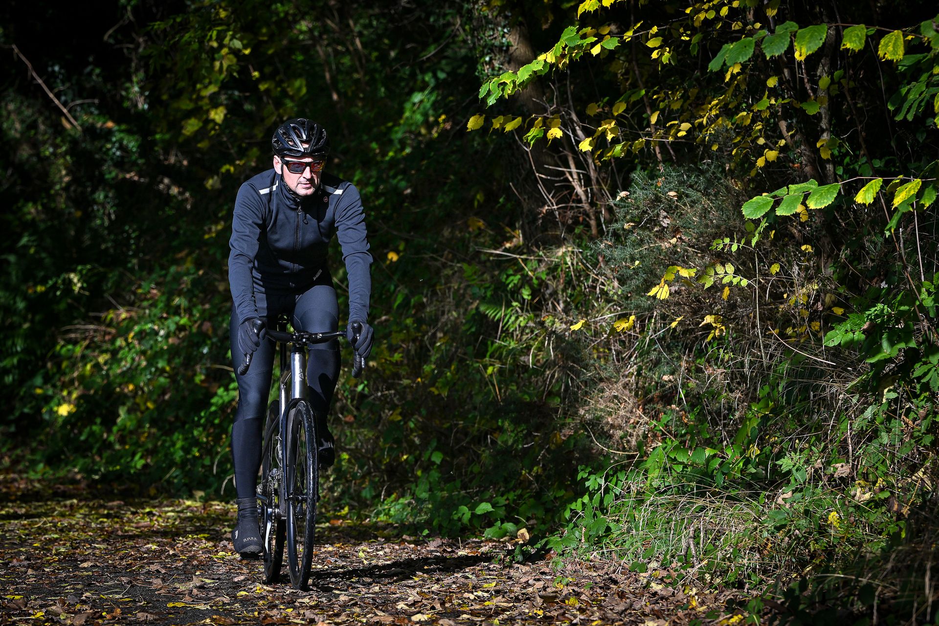 Male cyclist riding Ribble Allroad Ti Pro on a leaf-covered lane