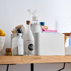 Open shelf used to store cleaning supplies and a cleaning caddy