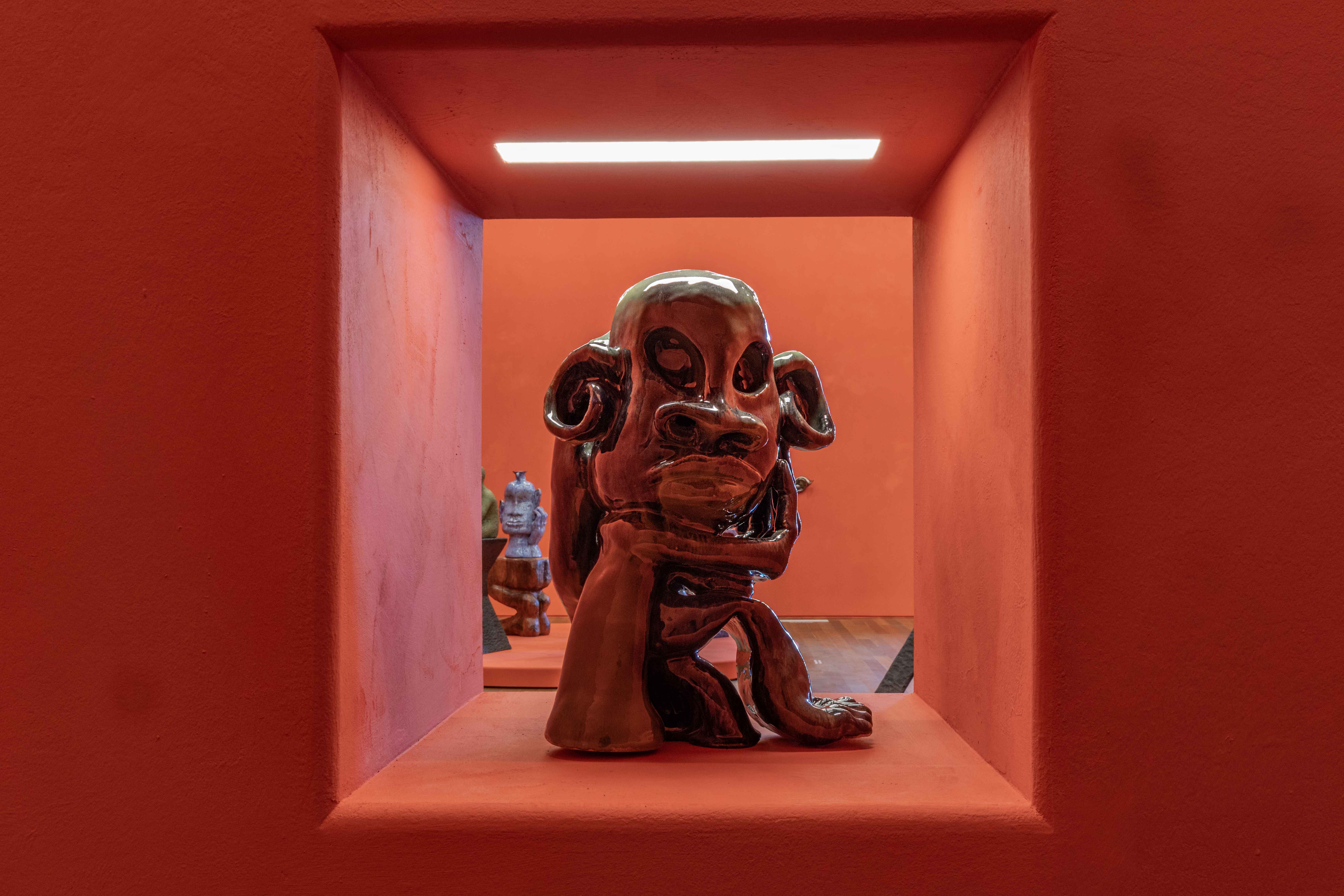 Woody De Othello sculpture on red background