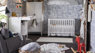 Nursery room with blue wallpaper and white cot