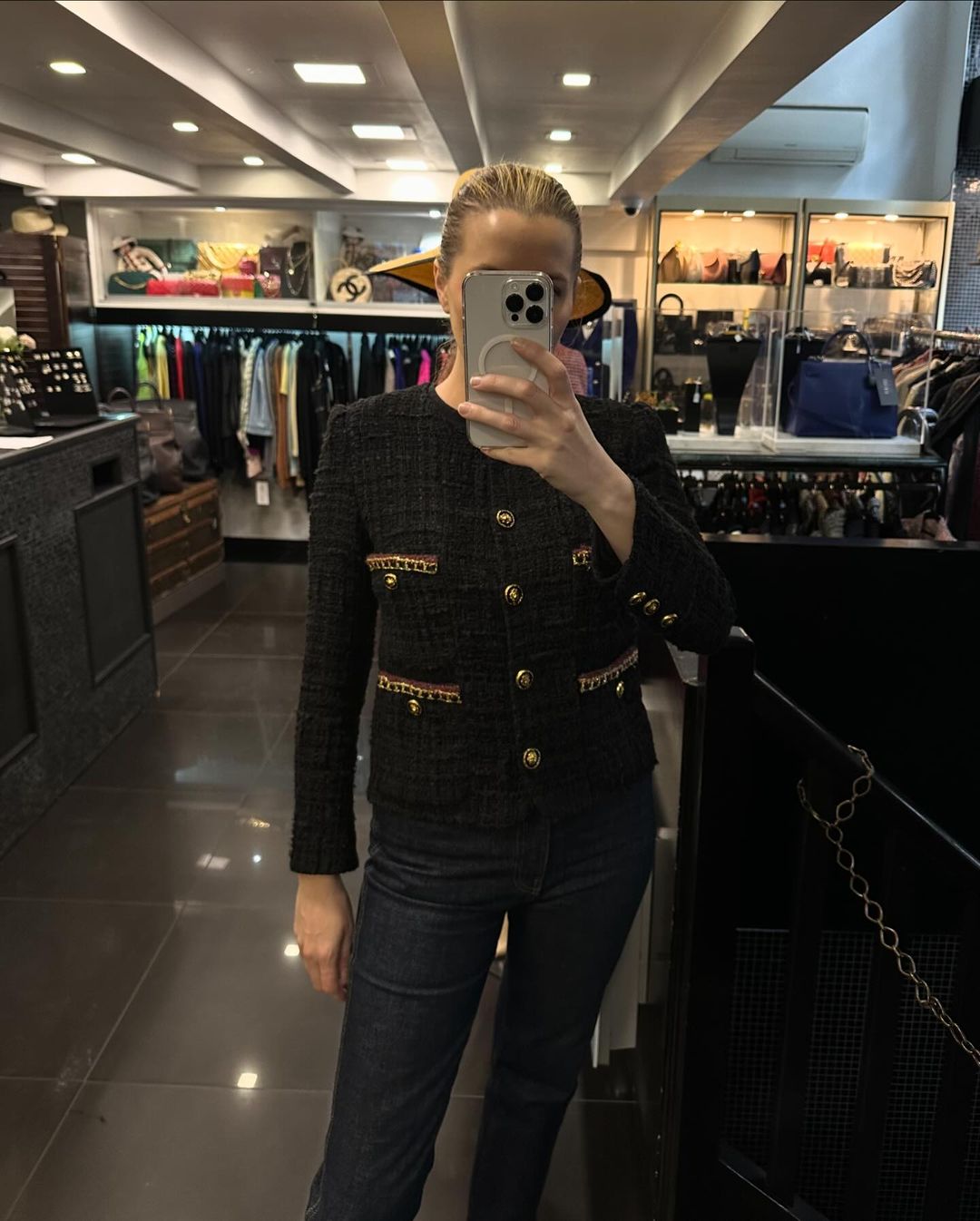Kristen Nichols taking a selfie wearing a Chanel jacket inside Valois Vintage, one of the best vintage stores in Paris.