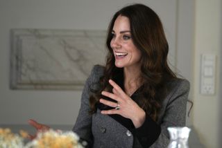 Catherine, Duchess of Cambridge speaks during a meeting with personnel during a visit to the Danner Crisis Center