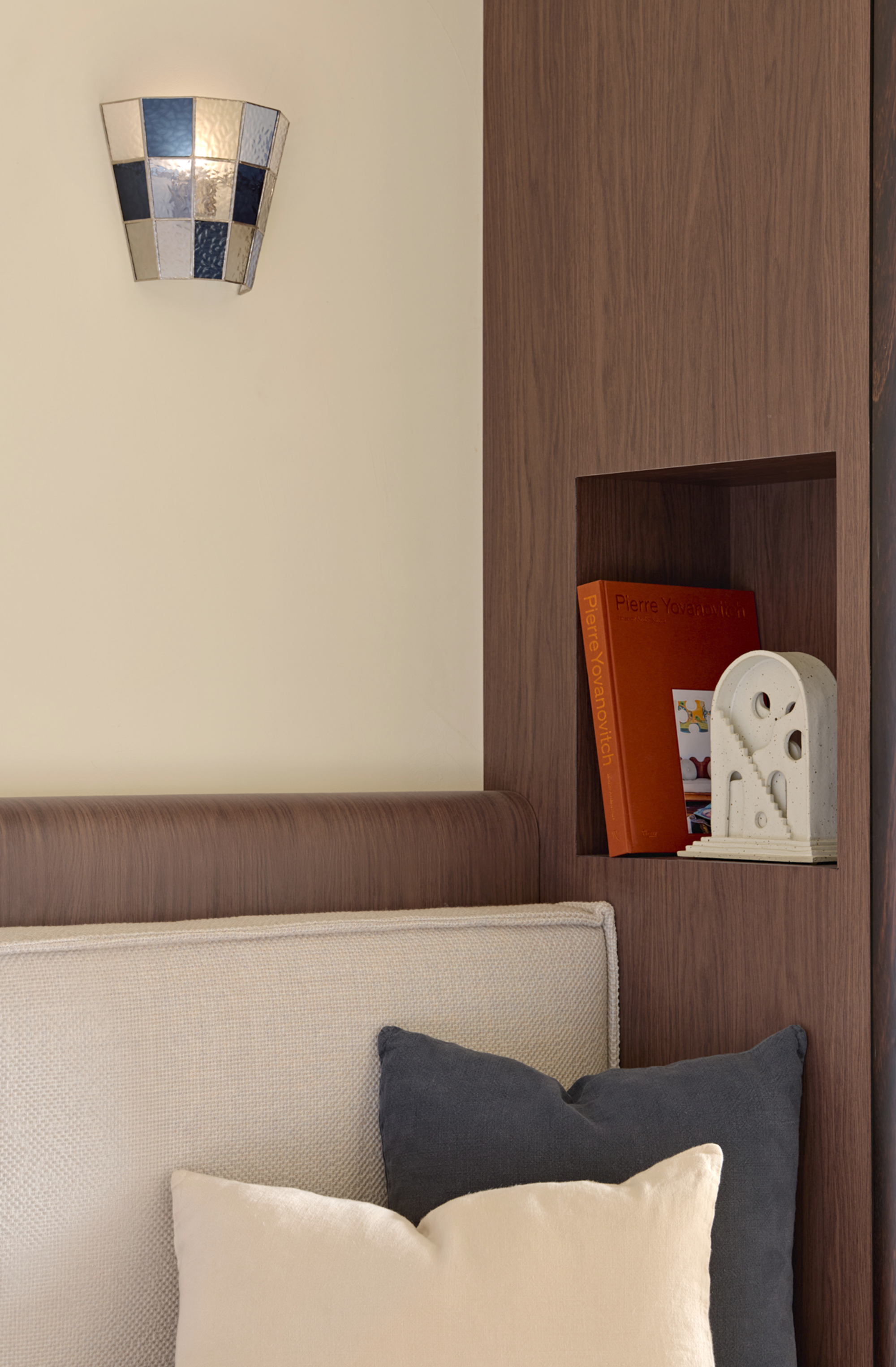 A modern bedroom with a stained glass sconce lamp