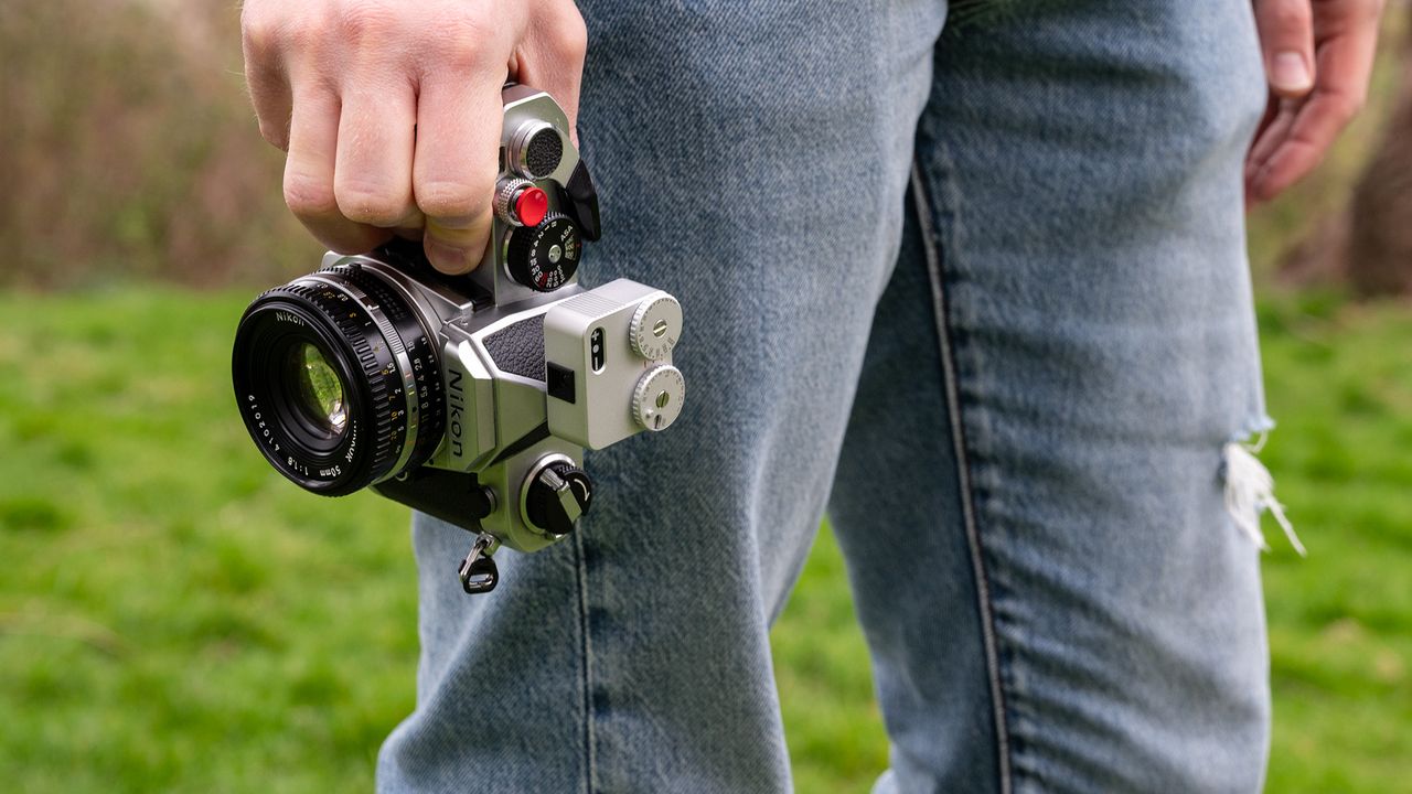 Person holding Nikon FM with the TTArtisan Light Meter II against jeans