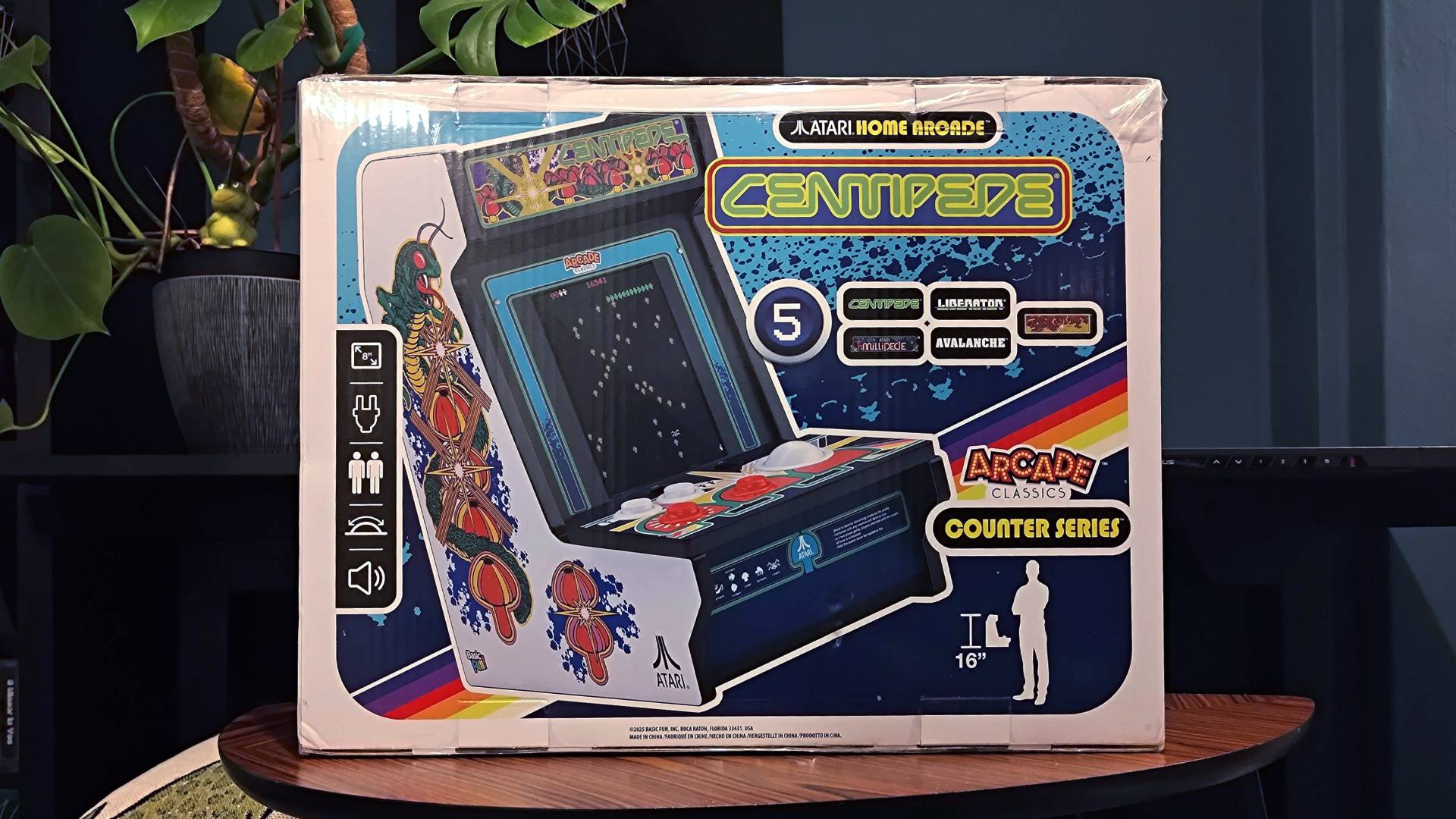 Arcade Classics Centipede box sitting on woodgrain coffee table.