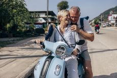 a happy couple riding on an electric scooter