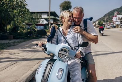 a happy couple riding on an electric scooter