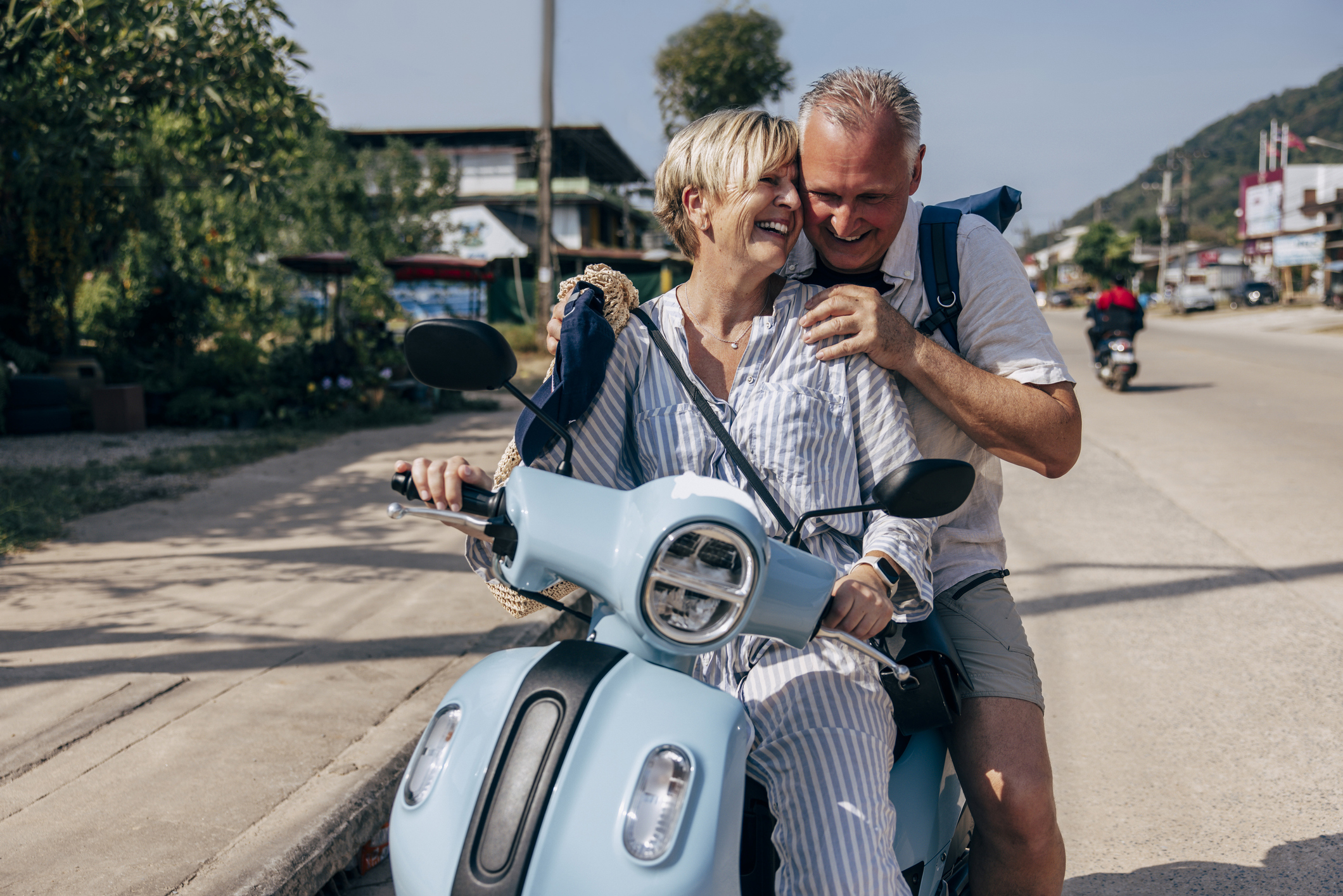 a happy couple riding on an electric scooter