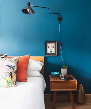 blue bedroom with black task wall lighting and framed prints - james french