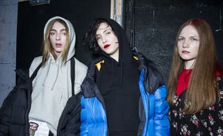 3 models wearing grey trackstuit top, blue padded jacket and reed and black top