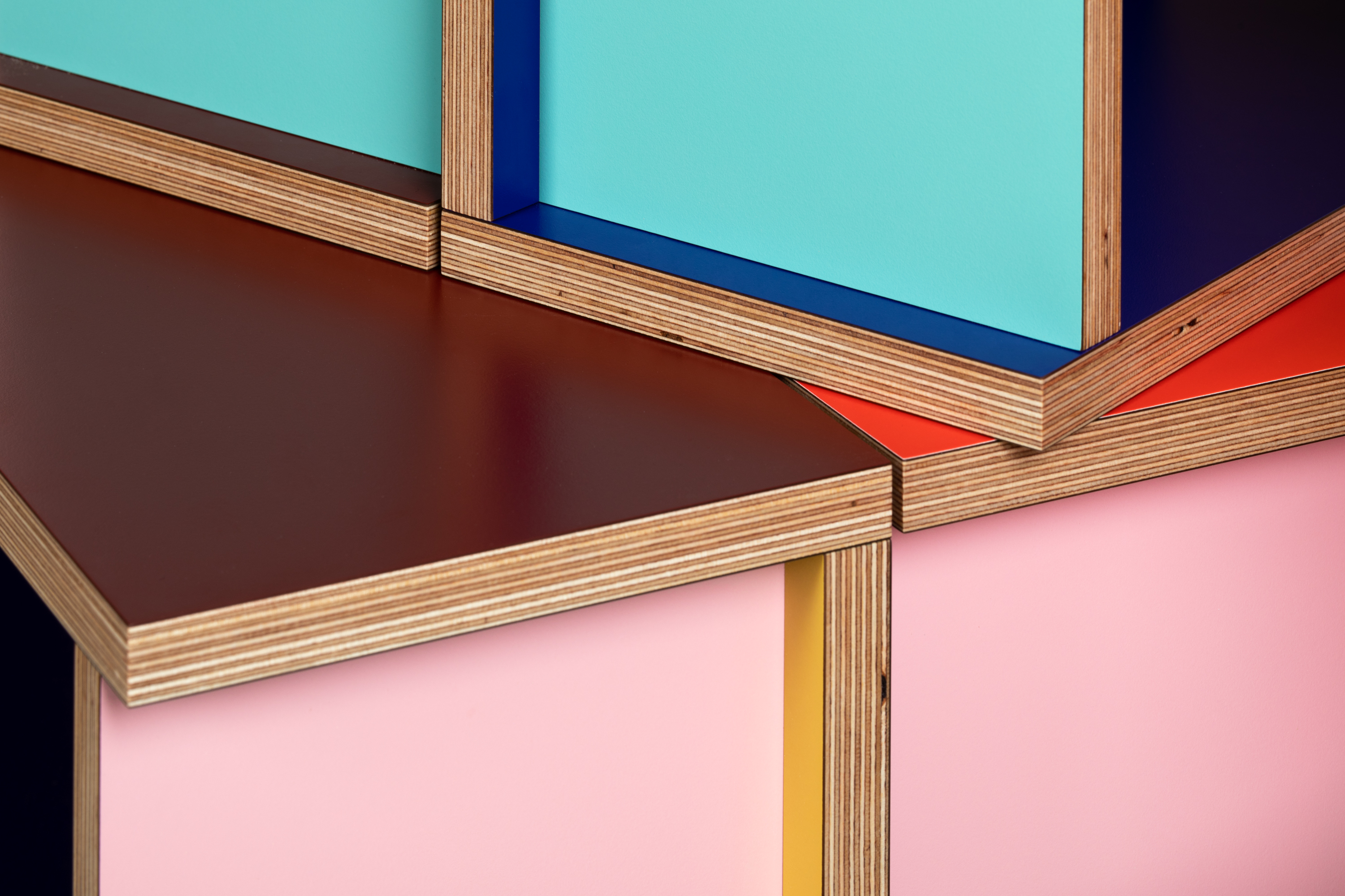 Tables made of colourful plywood sections intersected, made by Sophie Smallhorn for Uncommon projects