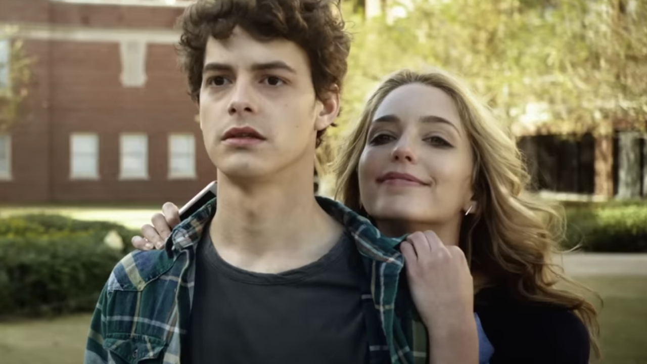 Jessica Rothe leaning on Israel Broussard's shoulders in Happy Death Day